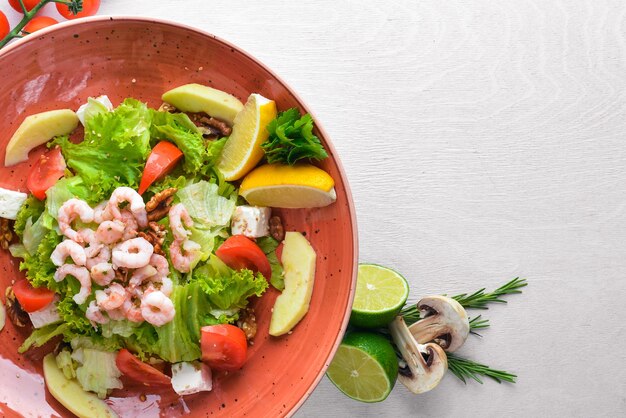 Shrimp Salad and Fresh Vegetables On a wooden background Top view Free space for text