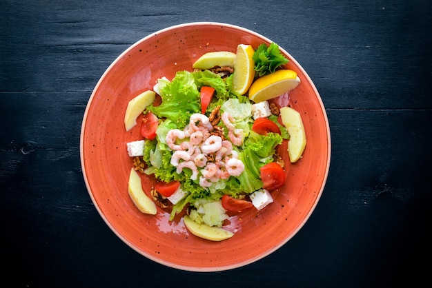 Shrimp Salad and Fresh Vegetables On a wooden background Top view Free space for text