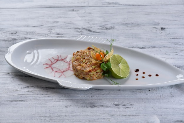 Shrimp and salmon tartare with avocado, lemon, sprouts and lime, seafood, top view