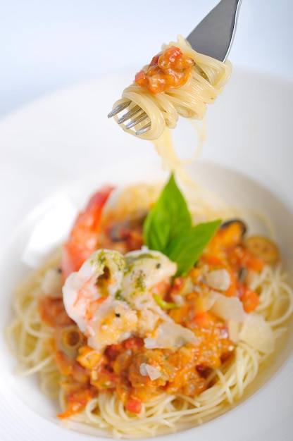 Spaghetti di gamberi con salsa di pomodoro su una forchetta. , cibo italiano