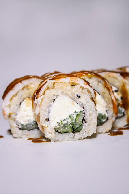 Photo shrimp sushi roll with a cucumber cream cheese and sauce on it