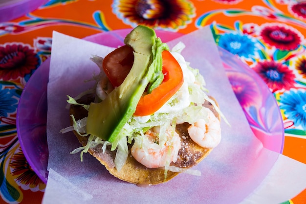 Shrimp taco. A taco is a traditional Mexican food consisting of a small hand-sized corn tortilla