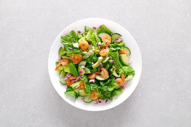 Shrimps avocado salad with cucumbers and lettuce Top view flat lay