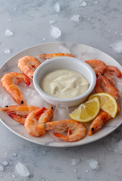 Shrimps on ice with white sauce.