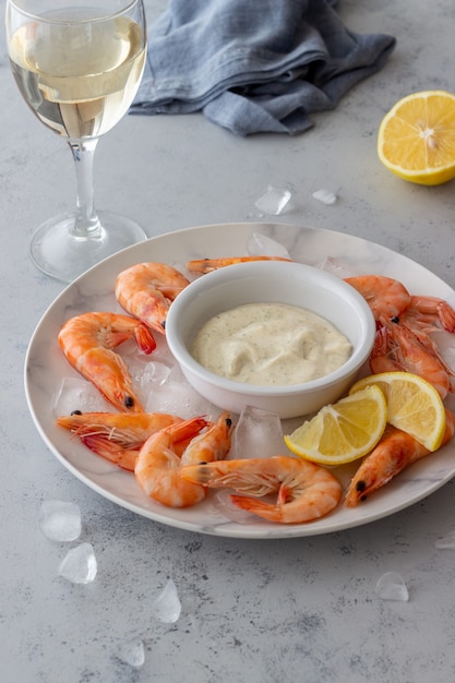 Shrimps on ice with white sauce.