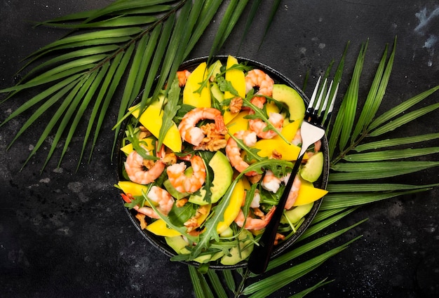 Shrimps Mango and Avocado Salad with Walnut Spinach and Arugula Healthy Eating food concept Top view gray background