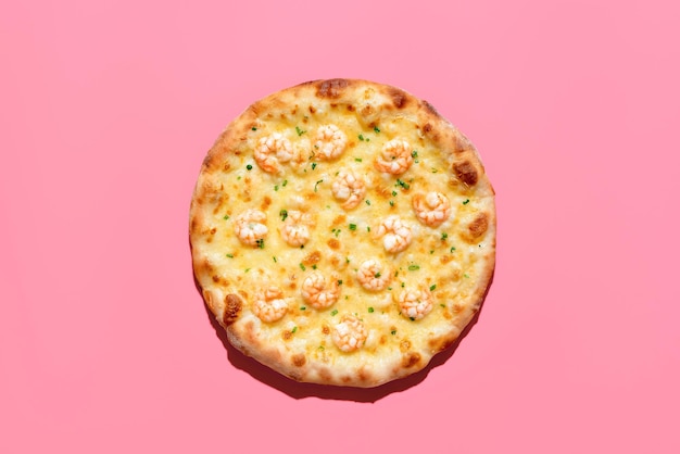 ピンクの背景に分離されたビューの上のエビのピザ