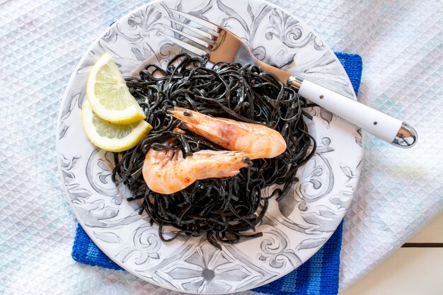 Shrimps with black seaweed and slices of lemon