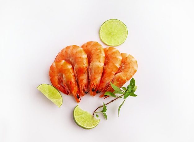 Shrimps with lime and herbs on a white background View from above