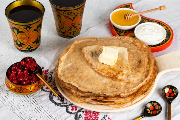 ShrovetideMaslenitsaフェスティバル。ロシアのパンケーキブリニ。はちみつとジャムのパンケーキ。ロシアのスプーン。全国ロシアフェスティバル。ロシアのクレープ。