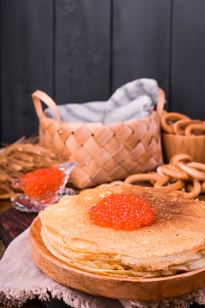 写真 shrovetide maslenitsa weekフェスティバルの食事。赤キャビア添えロシアのパンケーキのスタック。素朴なスタイル、テキスト用の空きスペース、