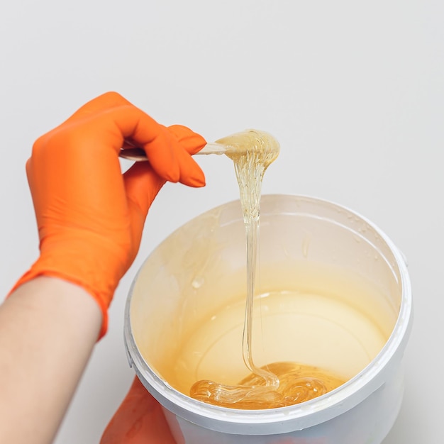 Shugaring master woman stirring sugar paste for hair removal