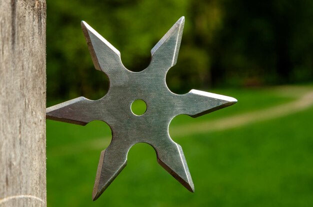 Shuriken throwing star traditional japanese ninja cold weapon stuck in wooden background