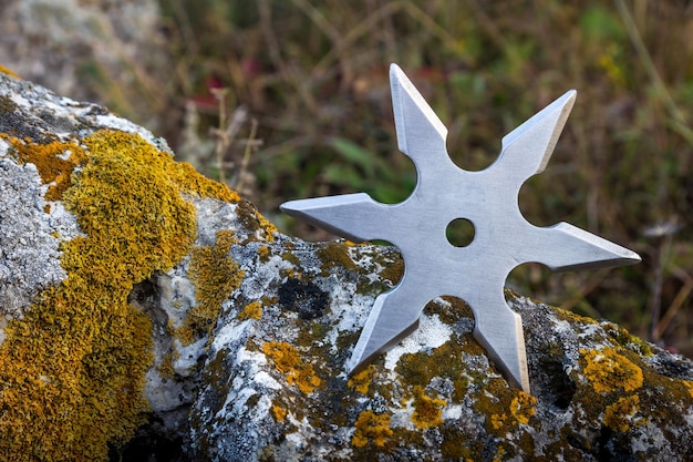 Foto shuriken stella da lancio arma fredda ninja tradizionale giapponese bloccata su sfondo di legno