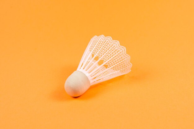 Shuttlecock on orange wall. Top view.