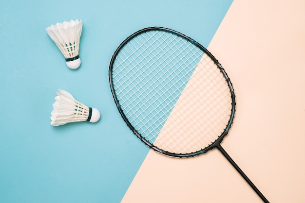 Shuttlecock and racket for playing badminton on a pÃÂ¡stel color background. Minimalism. Concept summer razlecheny