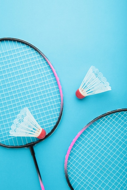 Shuttlecocks and badminton rackets on blue. Badminton equipment