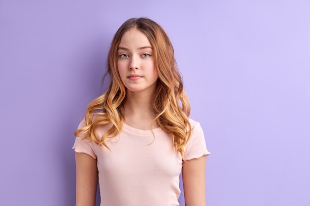 Shy caucasian teen girl looking seriously, shy and diligent female in casual wear calm and confident