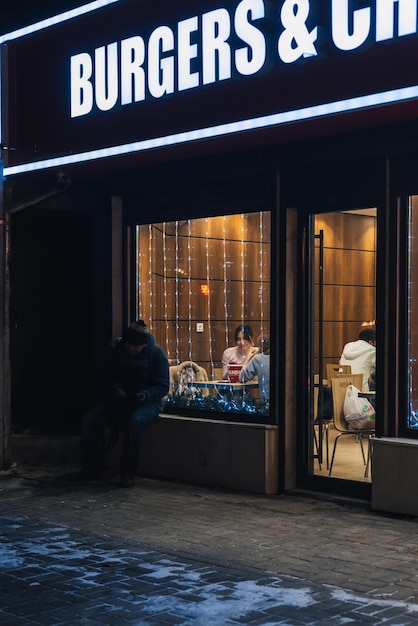 Фото Шымкент казахсан 23 января 2023 бездомный попрошайничает у окна кафе зимой