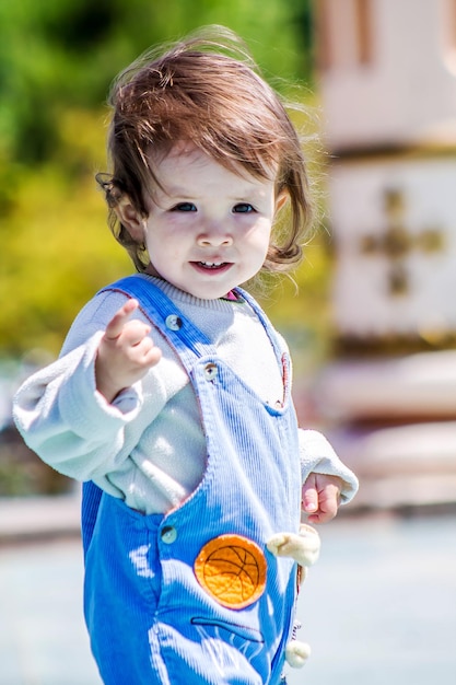 Foto shymkent kazakhstan 2 maggio 2018 un bambino piccolo con i capelli lunghi che si sviluppano nel vento gioca nel parco della città in una luminosa giornata di primavera