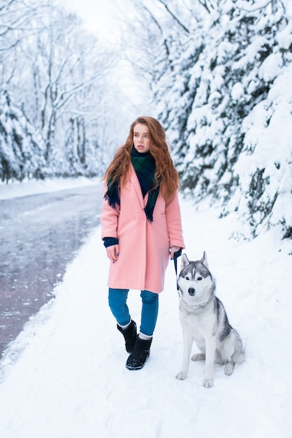 Siberian husky sitting near young woman