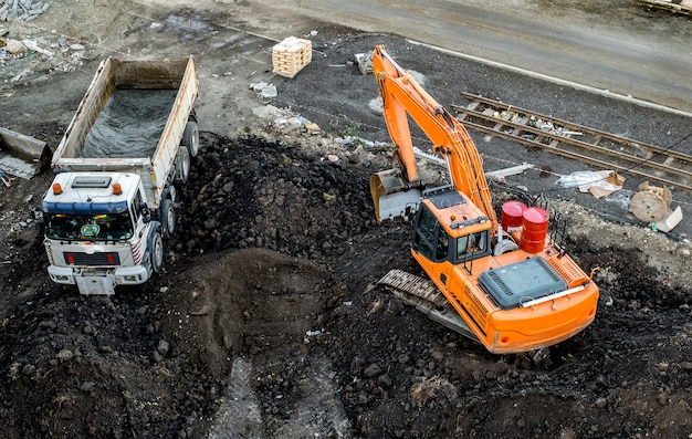 Foto sibiu roemenië - november 16 2019 graafmachine laadt aarde in de vuilniswagen