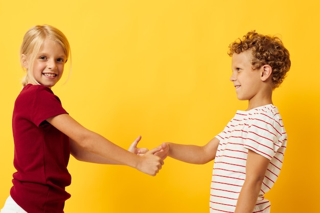 Photo sibling shaking hands against yellow background