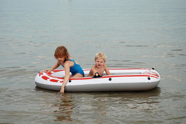 Photo siblings in boat on sea