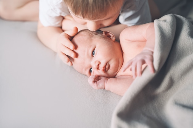 siblings bonding a boy and his little new born brother child and newborn baby one week old