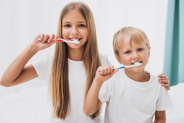 Siblings brushing their teeth together