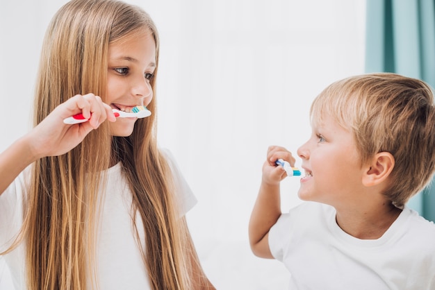 Photo siblings brushing their teeth