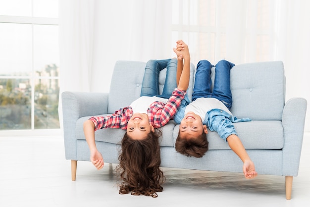 Photo siblings on couch edge with head hanging