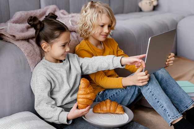 Photo siblings on couch with tablet