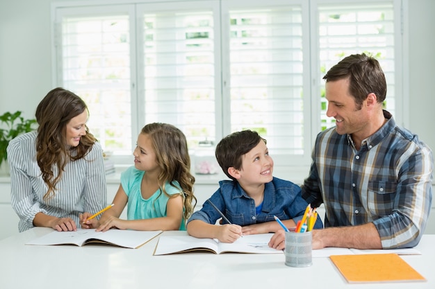 Siblings getting help with homework from parents