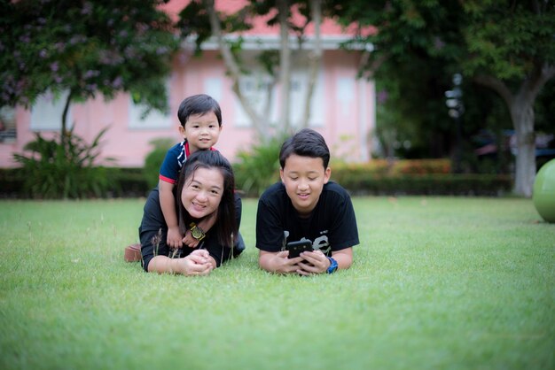 Siblings lying on grassy land in park