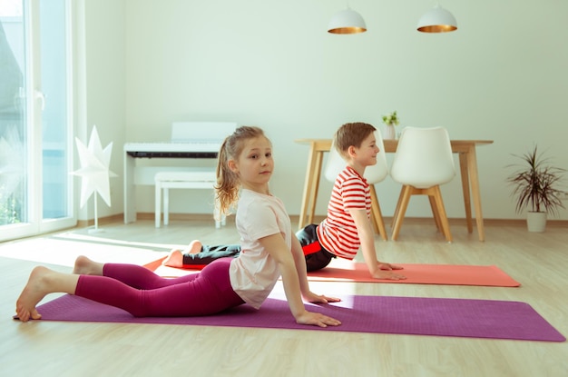 Photo siblings practicing yoga at home