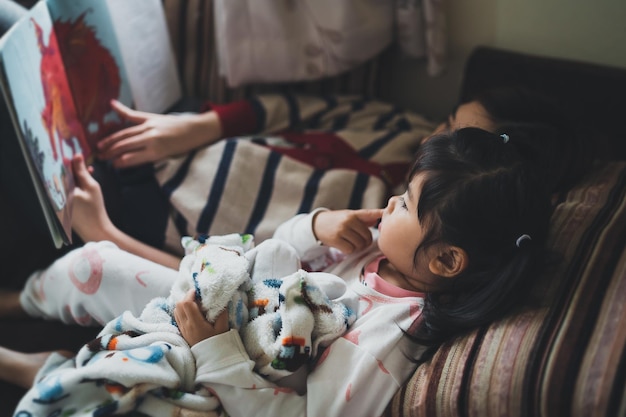 Photo siblings reading story book at home