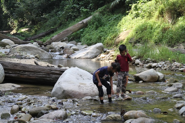 Photo siblings standing in river