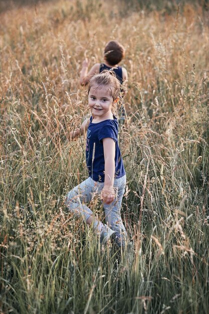 Siblings walking on field