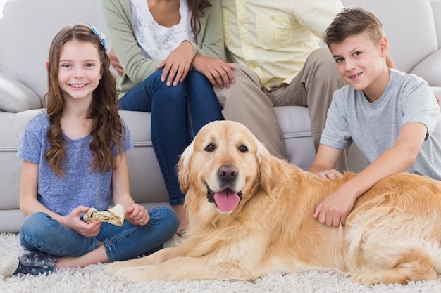 Photo siblings with dog and parents sitting behind