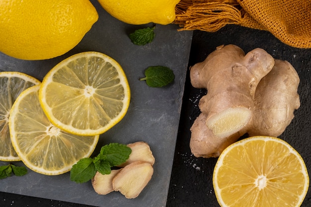 Sicilian lemons on slate stone with ginger and mint leaves.