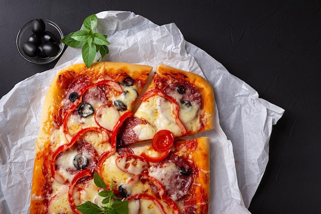 Foto pizza siciliana e verdure su fondo scuro