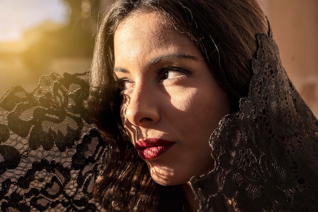 Sicilian woman dressed in black lace looks away