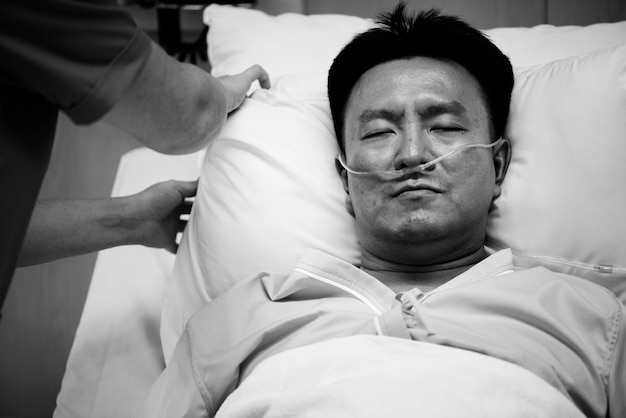 A sick Asian man in a hospital