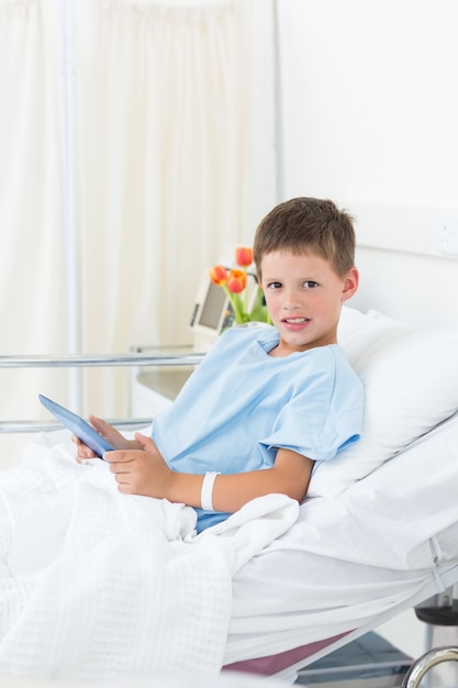 Photo sick boy holding digital tablet in hospital