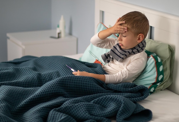 Photo sick boy resting on bed at home