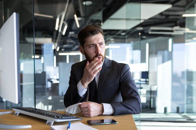 A sick businessman has a severe toothache an office worker works at a computer