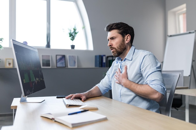 Sick businessman working in the office man worried and holding his hand to his chest severe heart pain