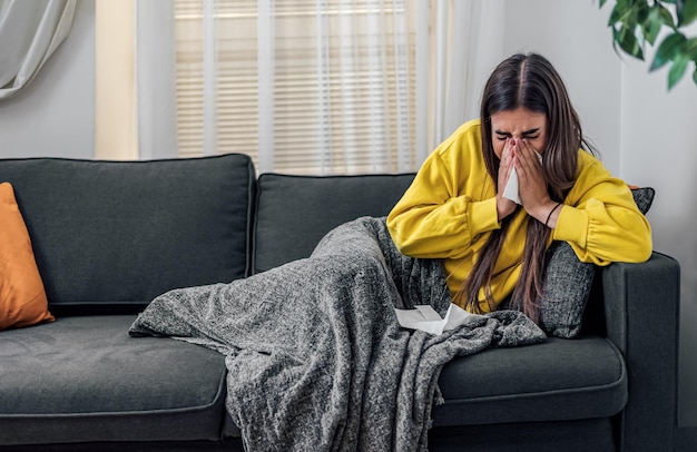 Sick caucasian girl having a flu blowing her nose