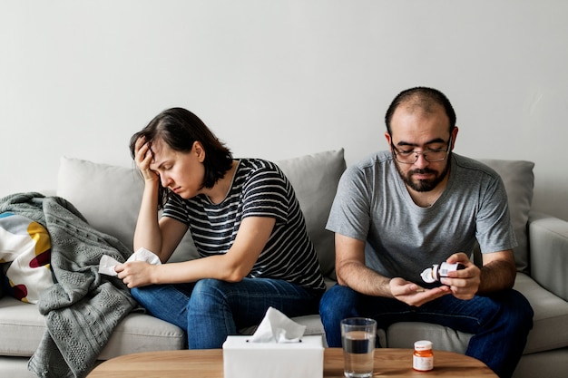 Sick couple sitting together on the sofa